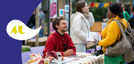 deux personnes discutant autour d&rsquo;un stand d&rsquo;information en ext&eacute;rieur