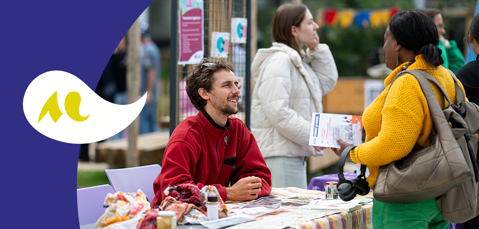 deux personnes discutant autour d&rsquo;un stand d&rsquo;information en ext&eacute;rieur