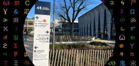 Premier plan, un panneau signal&eacute;tique ; arri&egrave;re plan , le b&acirc;timent Administration et l'amphi 700 de l'universit&eacute;